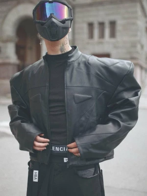 Rare Futuristic Cyberpunk Cropped Leather Jacket Extreme Padded Shoulders StatementPiece - Insane high-fashion silhouette leather jacket by Namilia. Features exaggerated structured padded shoulders, sharp geometric chest panels, and biker hardware details. Cropped fit that pairs perfectly with wide-leg trousers or cargo pants. Perfect statement piece for Cyberpunk, Opium, Y2K, Gothic, and Darkwear aesthetic looks. Condition: Like new — worn only once for a photoshoot. Model in photo 183cm 