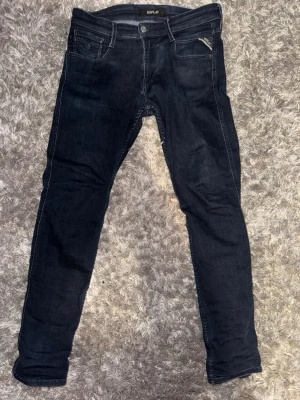 Replay anbass - Snygga svarta slim fit jeans från Replay med klassisk femficksdesign och dragkedjedetalj vid fickan. Jeansen har en smal passform och är tillverkade i stretchigt denim för extra komfort.