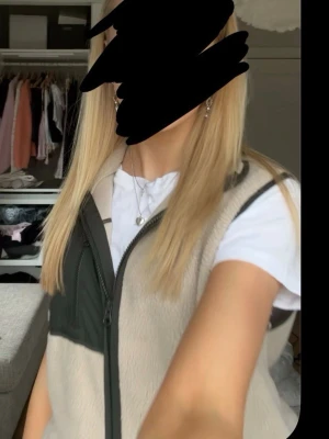Beige fleeceväst med svarta detaljer - Säljer en beige fleeceväst med gröna detaljer och dragkedja framtill. Aldrig använt den❤️