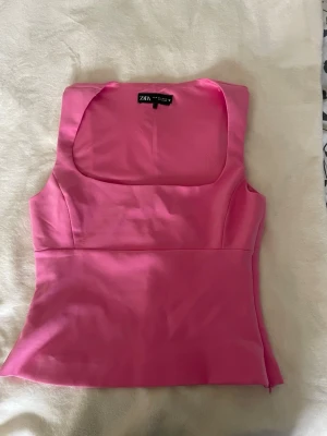 Rosa ärmlös topp från Zara - Snygg rosa topp från Zara med breda axelband och fyrkantig urringning. Sitter jättefint och passar mig som brukar ha S. Säljs då den inte används.                    !Pris går att diskutera! 