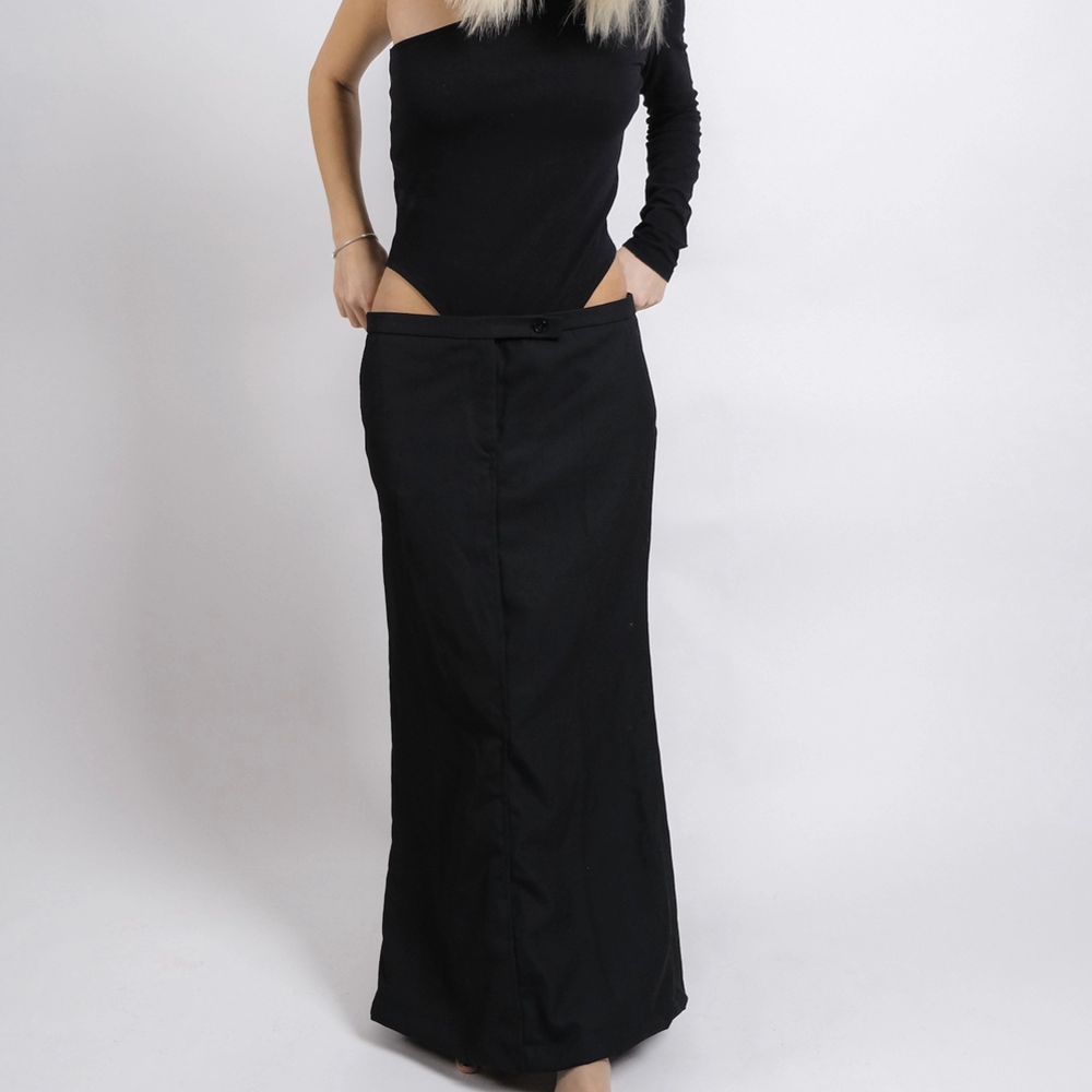 En svart långkjol i kostym material. Kjolen är omdesignad från ett par kostymbyxor till en kjol. Modellen på bilden är 170 cm och bär stl S/M. Passar både större som mindre beroende på önskad passform.  Storlek: M/L. Kjolar.