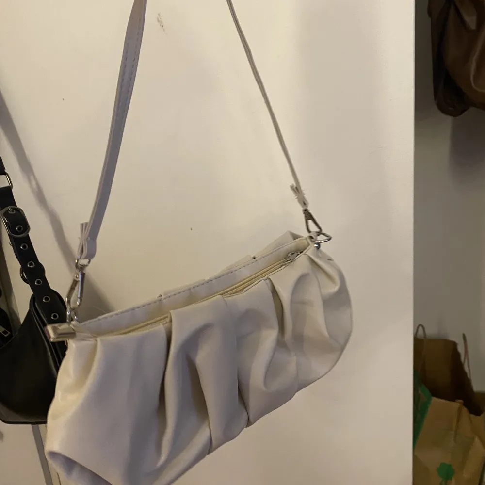 En beige väska som är skrynklig i modellen  Rymlig väska . Väskor.