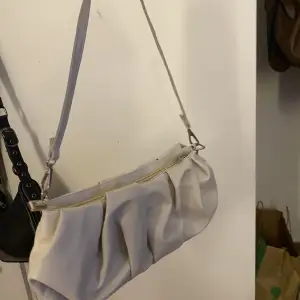 En beige väska som är skrynklig i modellen  Rymlig väska 