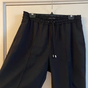 Svarta kostymbyxor zara - Tunna svarta kostymbyxor från zara med knytning i midjan. Storlek L, frakt tillkommer