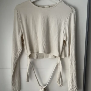 Långärmad snörtröja - Säljer en krämvit långärmad tröja från hm. En långärmad man knyter runt midjan och i ryggen. Strl L❤️styker den självklart innan frakt!
