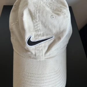 Nike keps - Säljer denna beiga kepsen från Nike som är perfekt i sommar! Får tyvärr inte själv användning för den💕