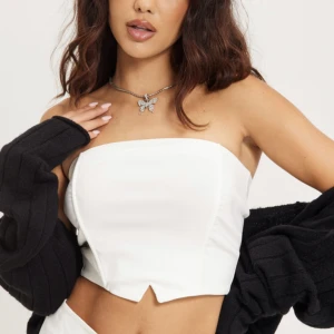 Crop top utan band - Vit crop top utan band från Nelly. Lite skrynklig men aldrig använd med prislappen kvar. Storlek S.