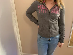 Hollister munkis munkjacka xs - En snygg munkis från Hollister stl xs. Grå med rosa text. Använd och älskad,