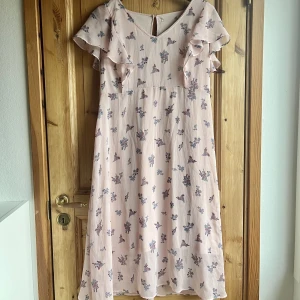 Blommig klänning - En babyrosa klänning med blommönster somt utomlands. Mycket fint fall och perfekt inför vår/sommar. Etiketten är avriven men annars i nyskick 🌸