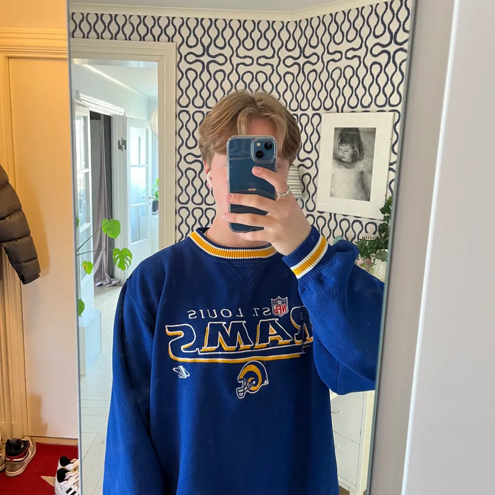 En blå vintage St louis Rams NFL sweatshirt. Tröjan är i bra skick utan något slitage. Tröjan är i storlek L men passar bra på mig som har M. Tröjan är i bra material. skriv gärna för fler bilder eller funderingar kring tröjan.. Tröjor & Koftor.