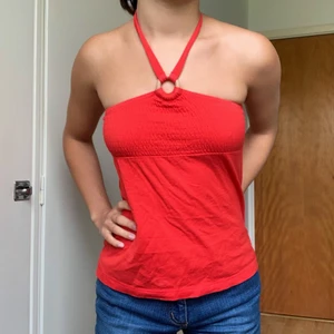 Halter topp - En haltertopp i röd färg och sktretchigt material. Knäpps bakom nacken. Ringen är i trä. Barn stl, men passar en xxs/xs. 🥰