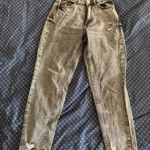 Gråa jeans - Ett par snygga  mom jeans som är grå med svarta detaljer. Säljer eftersom dom är för små för mig. 