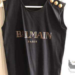 T-shirt linne ifrån Balmain i svart med detaljer i guld. Aldrig använd! Nypris ca 3500kr