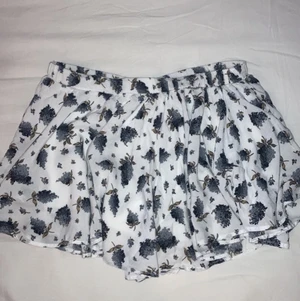 Blommig mini-byxkjol - Minikjol från ca. 2017 men använd typ 2ggr så nyskick skulle jag vilja säga.  Inga lappar men passar mig som brukar ha strlk XS/S, mitt midjemått är 66cm och jag är 1,61 m lång. Väldigt stretchig. Ser ut som en kjol men är mer som ett par flow-iga shorts.