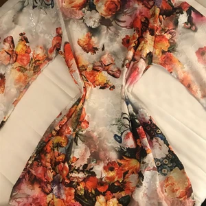 Klänning - En mycket vacker sommarklänning med skärp i midjan, målad med blommor i gult, orange, svart och vitt, detaljerna är väldigt vackra.  Den har vida ärmar, är ovanför knäet och är gjord av chiffong😍😍😍😍