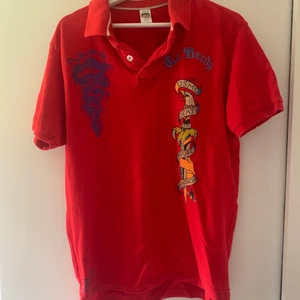 Ed Hardy tröja - Ed Hardy tröja med krage. Aldrig använts, i rätt okej skick. Tröjan har rivit upp sig på några ställen, väldigt lite men forfarande synligt (sista bilden) 