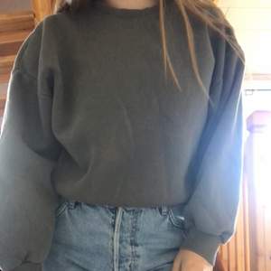 En grå croppad sweatshirt i storlek M från Gina