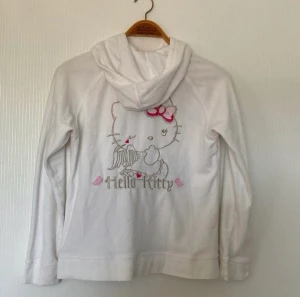 Hello Kitty zip hoodie - Perfekt skick. Den kommer från H&M från deras H&M x Hello Kitty collection. Det är en storlek M men passar även L och S beroende på hur man vill att den ska sitta.📣PRIS KAN DISKUTERAS📣jag kan skicka bilder med den på. Läger up igen så att flera kan se.