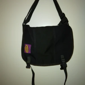 Retro / vintage äkta Timbuk2 väska / messenger bag / budväska. Svart. Orginal. 90-tal. - Retro / vintage äkta Timbuk2 väska / messenger bag / budväska. Svart. Orginal. 1990-tal. Använd med fortfarande brukbar. Totalt ca 5-6 st fack inuti. Praktiskt foder som går att torka av. Reflexer och midjeband saknas. Ca 37 cm hög, 27 cm bred, 17 cm djup