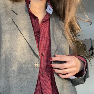 Rödrutig skjorta - En rödrutig herrskjorta med blått inslag på insidan av kragen och ärmarna. Supersnygg och perfekt för layering!🤩 supernice att slänga över långärmad, linne och likväl badkläder!