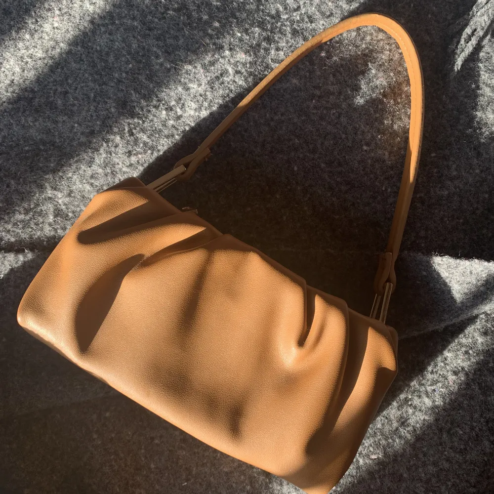 En fin brun handväska med guld detaljer. Ett litet fack innuti och ett stort💞💞. Väskor.