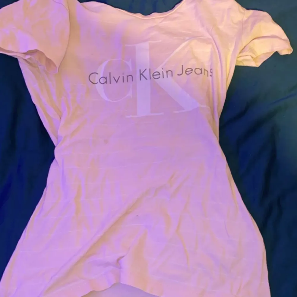 En rosa Calvin klein T-shirt, den har en blå acktig fläck på axeln inuti tröjan. Jag säljer den eftersom att den aldrig kmr till andvändng köpte den för ca 600kr men säljer den för 350kr. T-shirts.