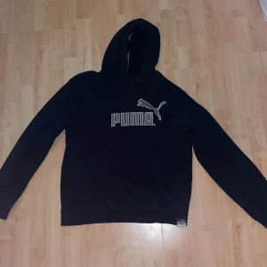Puma Hoodie i svart - Puma hoodie, svart och grå puma text. Mindre i storleken på. 