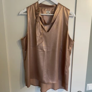 River Island topp  - Oanvänd topp från River Island. Storlek 14 som motsvarar L. Färgen är dimrosa eller beige. 