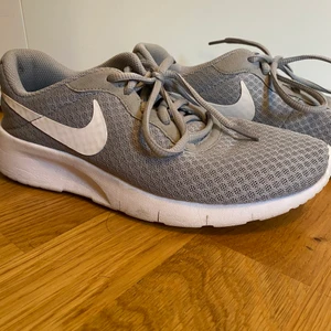 Nike skor - Nike - Tanjun Grey skor. Använda 2-3 ggr och i nyskick, perfekta att ha som antingen inneskor eller uteskor. Storlek 38.5 och nypris 600kr, jag säljer för 150kr + frakt 🥰