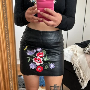 Skinnkjol med brodys - Super söt skinnkjol med broderade blommor på! Bra skick