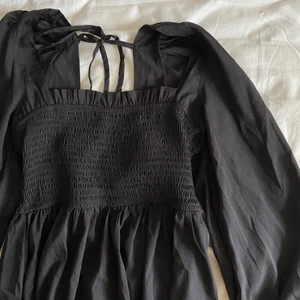 Svart klänning  - SÅ SÖT SVART KLÄNNING🖤 square neckline och knytning därbak samt stretchig byst och ballongärmar! Aldrig använd och köpt från nakd men är inte riktigt min stil🖤 passar både till fest och till vardags och är SÅ bekväm! 