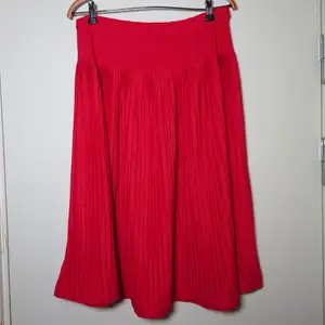 Röd, äldre, klockad kjol med resår. Märkt som 38/40 men är som en L🌻
