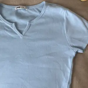 En baby blå t-shirt med V urringning. Använt fåtal gånger men i väldigt fint och bra skick!
