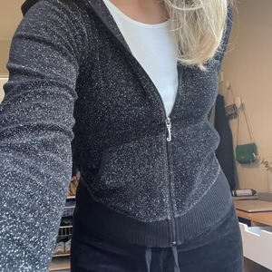 Juicy-set  - Ovanlig glittrig och svart Juicy-dress i den äldre modellen. Tröjan har därför det gamla ”J:et” och fint tryck på ryggen. Byxorna är lågmidjade och alla rhinestones sitter kvar