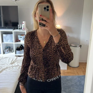 Leopardmönstrad blus - En söt leopardmönstrad blus från hm. Den har knytningar på sidan som en söt detalj. I fint skick utan defekter. Pris går att diskuteras!