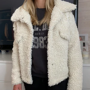 Kort Teddy jacka  - Säljer denna vita Teddy jackan ifrån Gina i storlek S. Köpt för ngt år sedan så finns ej kvar och använd endast ett fåtal gånger. Super snygg och perfekt nu till hösten!! Priset går att diskutera