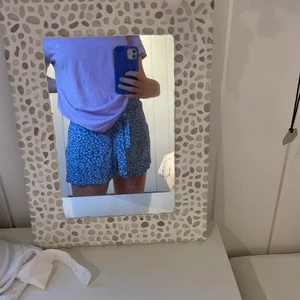 Blå short från hm💙 - Blå shorts från hm som är oanvönd med vit blommigt mönster🦋💙🌸 Resårband i midjan och en rosett som man kan knyta☺️! Priset kan diskuteras!
