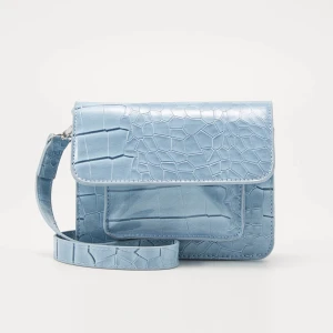 HVISK Axelremsväska - dustyblue - HVISK cayman mini Product information · Material: 100% polyurethane · Dustbag: No · Strap length: 107 cm · Width: 17 cm · Height: 12 cm · Depth: 5 cm.