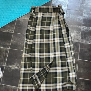 lång grön kjol hm - En lång khaki-grön rutig kjol från hm. Köpt för typ ett år sen men använd typ 1 gång. Kostade typ 200kr. 