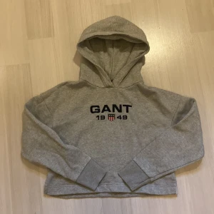 Gant hoodie  - En jättefin grå gant hoodie i fint skick, slits på sidan och är kort i modellen.  Storlek 146-152 (11-12 år) och säljs för 90kr