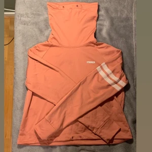 Hoodie / Turtleneck - En hoodie / turtleneck från stronger i rosa. Tjock material - funkar bra ute. Obs banden är borta. Nyskick. Storlek M. 100kr + frakt (cirka 50kr)