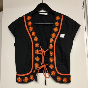 Väst/topp från Sol&Måne  - Superfin liten väst från Sol&Måne som tyvärr inte kommer till användning. Perfekt för layering till hösten! Insydd i midjan med två darts men går att sprätta upp så storleken blir m-l. Säljer även en likadan fast med röda blommor!