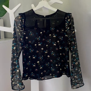 Blus Zara - Säljer denna gulliga blus från Zara då den är för liten för mig. Svart med blommor och ett tunnare fint tyg, en liten öppning med knapp i nacken. Storlek XS, 100% polyester. Kan mötas upp eller skickas, köparen står för frakten💞