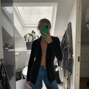 Glittrig kavaj  - Glittrig kavaj med långa ärmar, man kan välja att ha den knyten eller öppen och bära den med olika toppar under eller bara för sig självt. Från Gina Tricot i storlek XS.