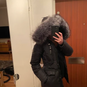 Hollies Livingo jacka strl 34 - Hollies Livingo jacka i storlek 34! Säljs med tillhörande grå fejkpäls-luva (som däremot ser väldigt äkta ut!) Nypris låg på 3800kr, därför säljer jag den nu för 900kr eller högsta bud.   Mvh