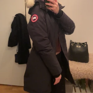 Äkta canada goose Victoria parka jacka  - Säljer min canada goose jacka som är använd en vinter, är i väldigt fint skick! köpt på Johnells förra året för 10.000 men säljer för 7000!  Storlek xxs, Jackan är mörkblå/svart. Pm för fler bilder! 