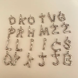 Berlocker  - Berlocker med bokstäver i silver. 10kr/ st eller alla för 40kr. Frakt 14kr För ungefärligt mått är bokstaven i 1,2cm 