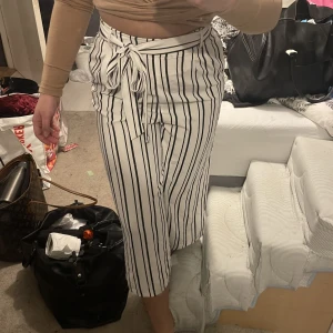 Randiga kostymbyxor - Svart/vit randiga kostymbyxor från Amisu. På mig som är 156 går de ner till hälften av vaden så lite längre än 3/4 byxor. Storlek 36.