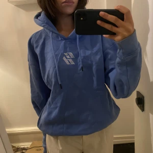 Blå hoodie  - Blå hoodie med tryck fram på bröstet i rhinostenar