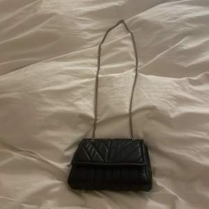 Säljer en svart väska med silvriga kedjor ( be är lite rostig och lite skador )